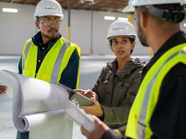 Drie mensen die in een warehouse werken